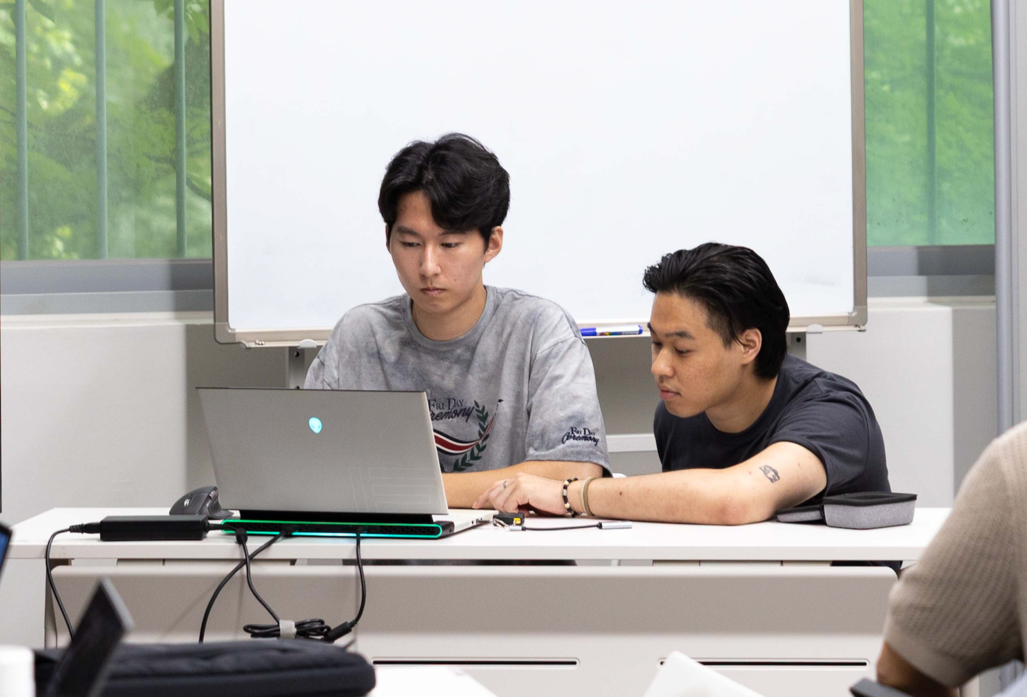 테이블에서 노트북을 함께 보는 두 사람